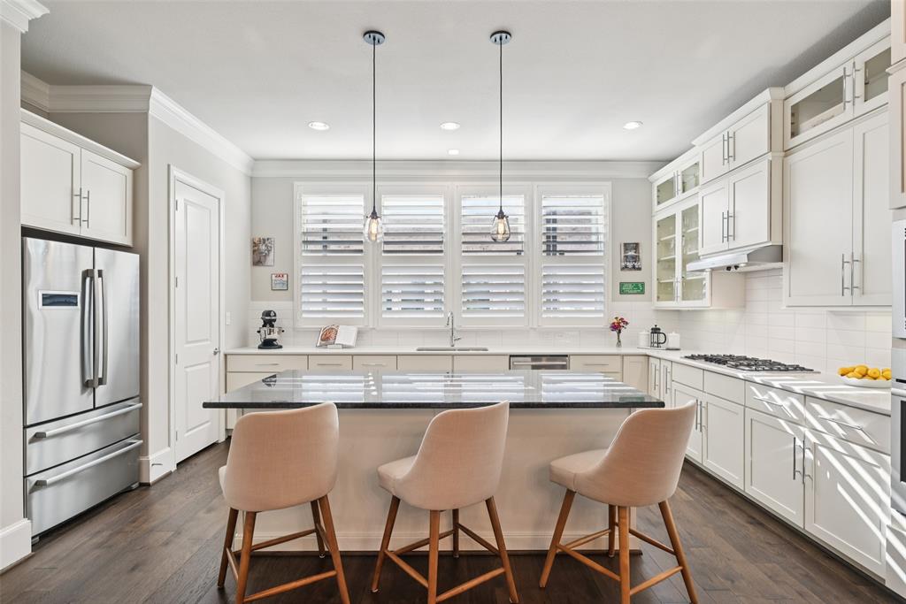 2815 Lynlock Court Dallas, TX 75219 - Photo 7 of 39 a kitchen with stainless steel appliances granite countertop a sink a stove a refrigerator and island with wooden floor