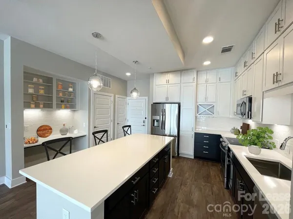 a kitchen with stainless steel appliances granite countertop a stove refrigerator and microwave