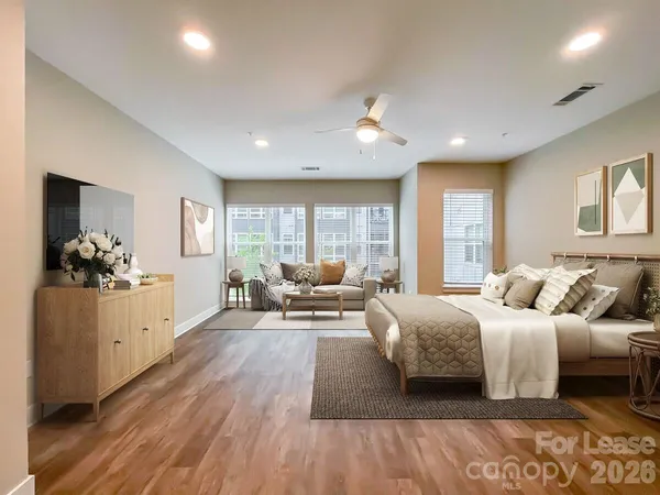 a living room with furniture a large window and stainless steel appliances