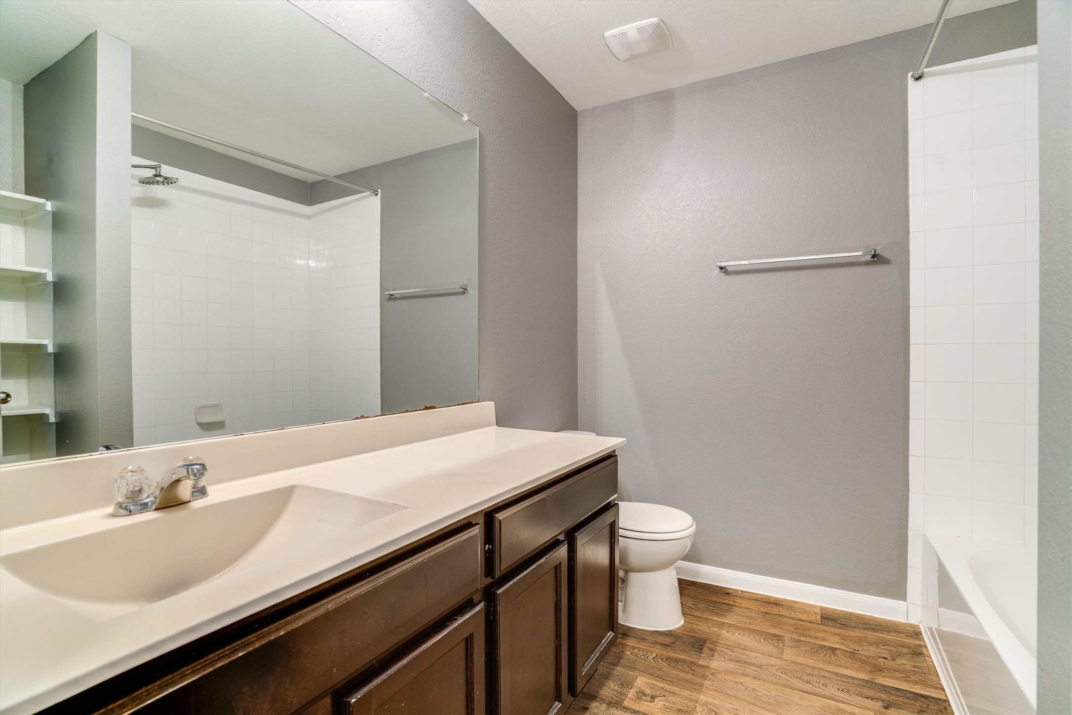 15128 Shell Bark Cove Austin, TX 78724 - Photo 20 of 25 A well-appointed bathroom features a single vanity, a toilet, and a combined shower-tub unit.