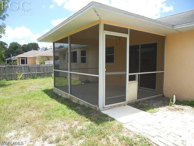 8402 Butternut Road Fort Myers, FL 33967 - Photo 12 of 13 a view of backyard with large trees and wooden fence