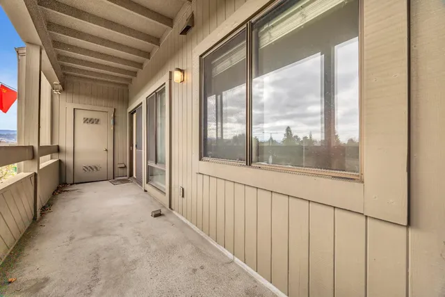 a view of a porch with wooden floor and windows