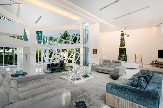 a living room with furniture fireplace and large windows