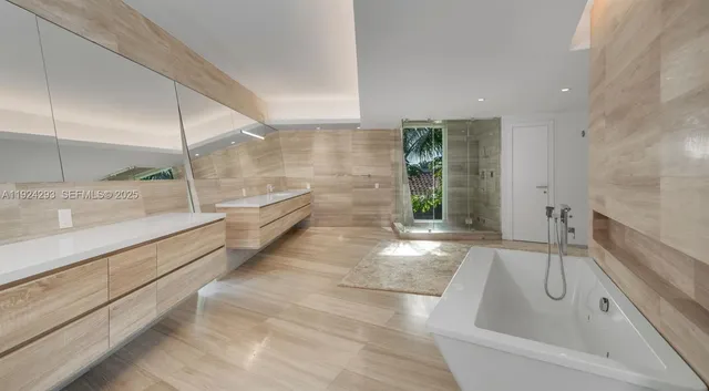 a bathroom with a tub sink and mirror