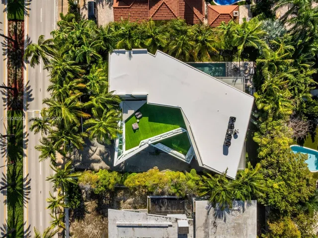 an aerial view of a house with a yard and swimming pool