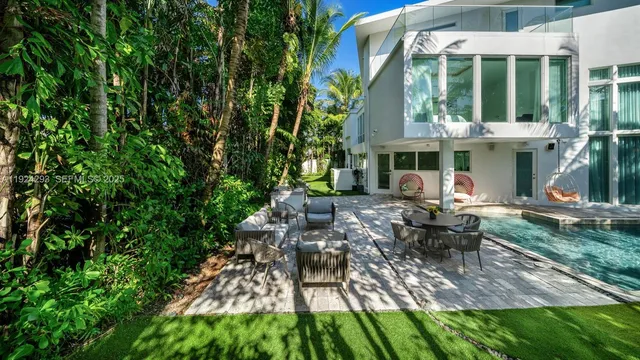 a view of backyard of house with outdoor seating and green space