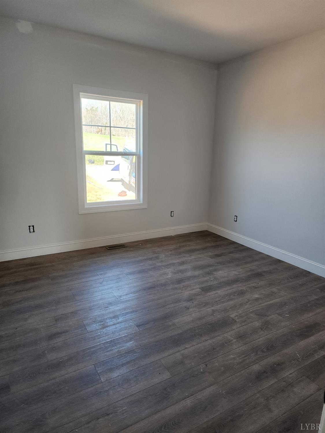 3025 Hawkins Ridge Road Goode, VA 24556 - Photo 7 of 8 an empty room with wooden floor and windows