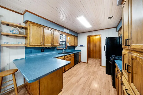 a kitchen with stainless steel appliances granite countertop a refrigerator a stove and a sink with cabinets