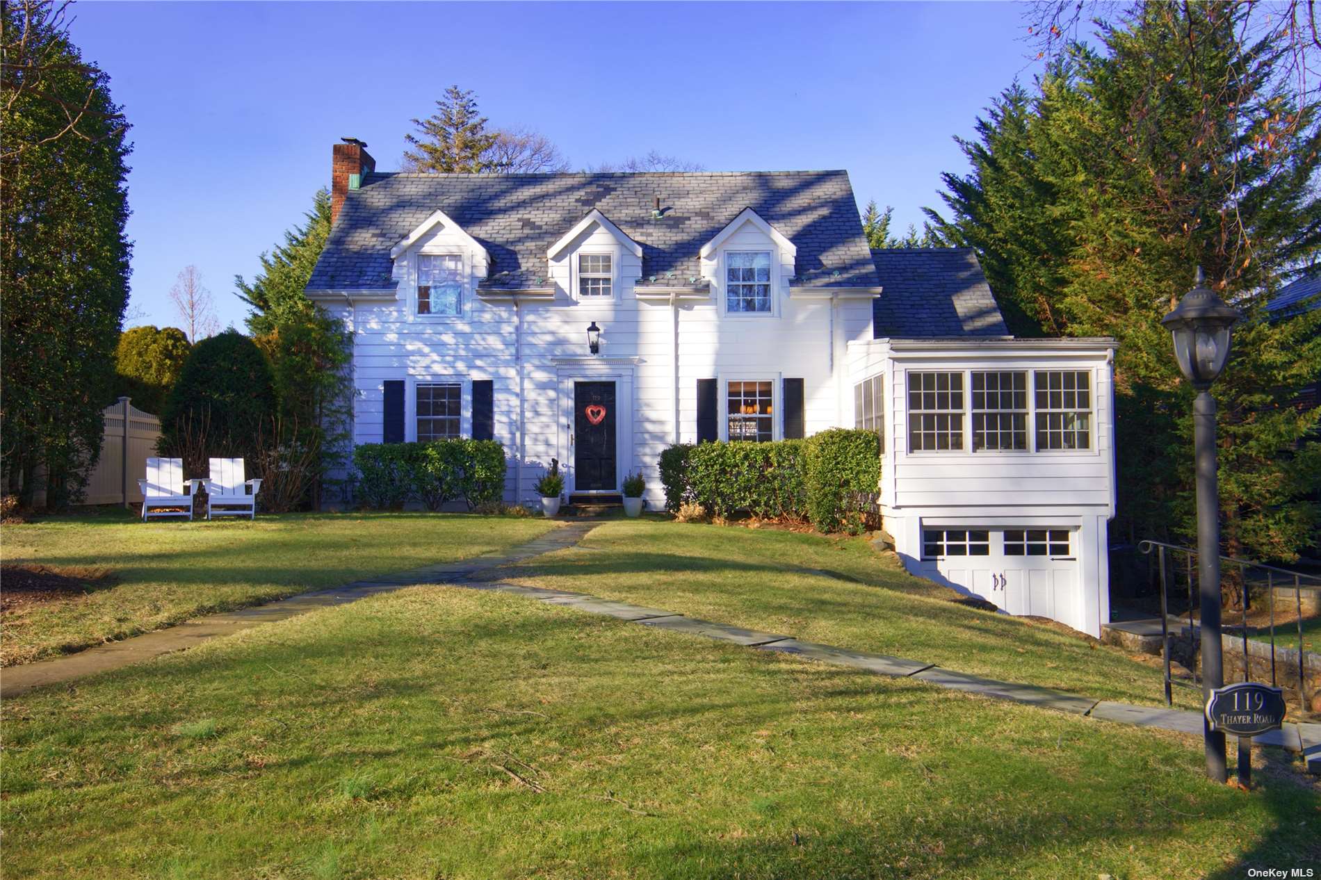 119 Thayer Road Manhasset, NY 11030 - Photo 1 of 1 a front view of a house with a garden