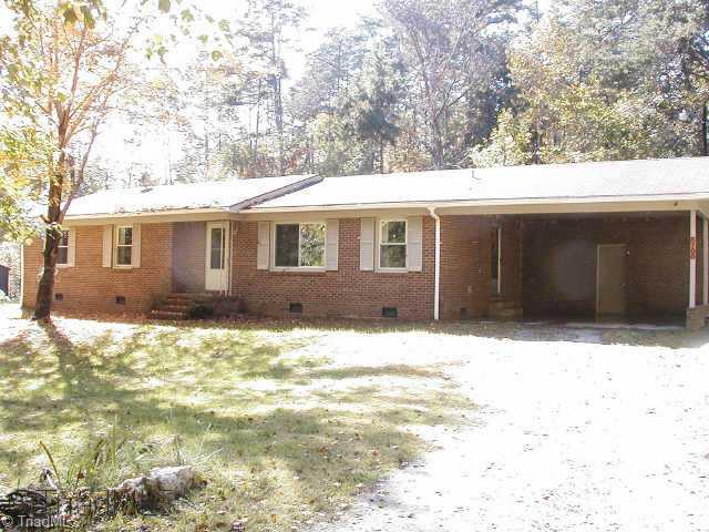Exterior Front. Very private lot thats partially wooded (can t see another home). All brick ranch w/vinyl exterior trim, new gutters & vinyl replacement windows. 2-car carport w/workshop that has 2 windows. Country living yet short commute to downtown Greensboro