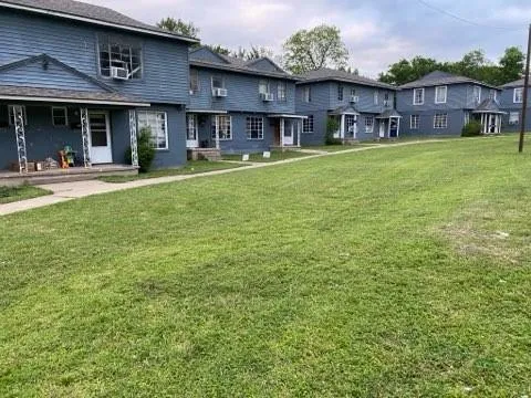 a view of a building with a yard and plants
