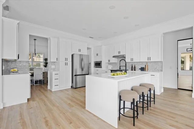 a kitchen with white cabinets and stainless steel appliances