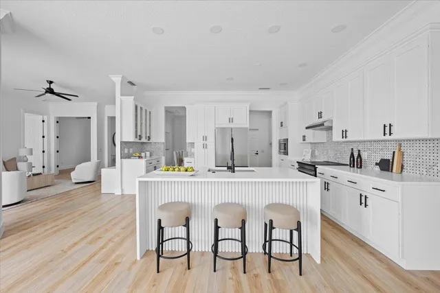 a dining room with wooden floor a chandelier a wooden table and chairs