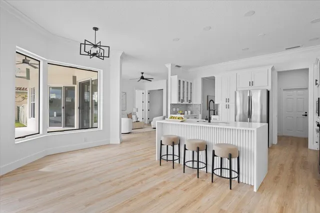 a large kitchen with a lot of counter space and wooden floor
