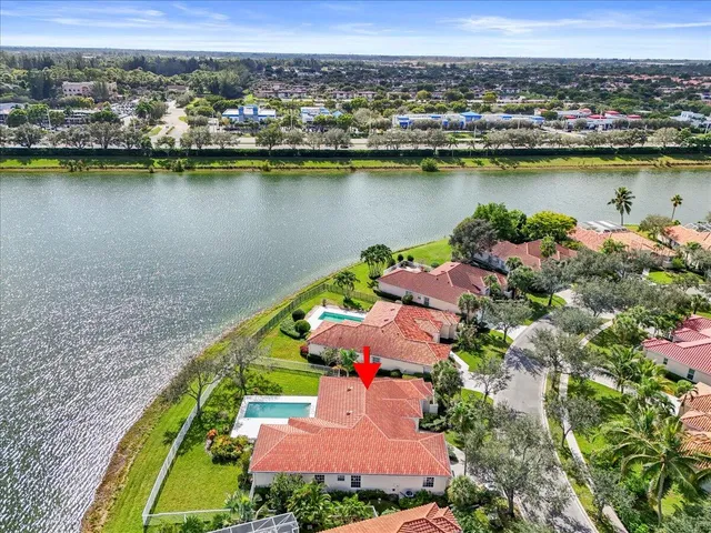 an aerial view of residential houses with outdoor space and lake view