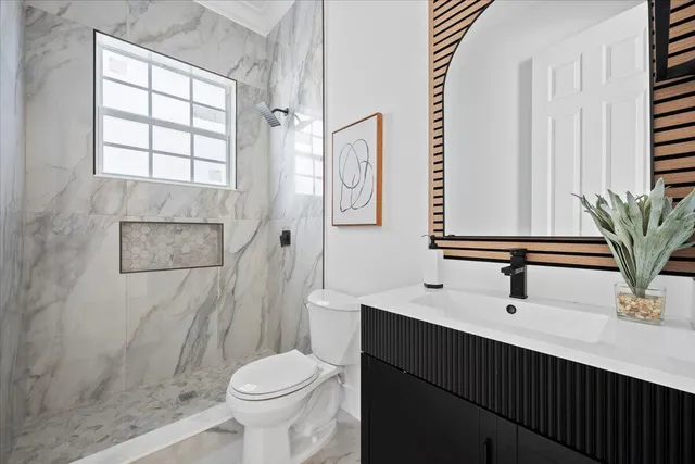 a bathroom with a double vanity sink mirror and next to a window