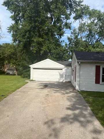 a white house with tree in the background