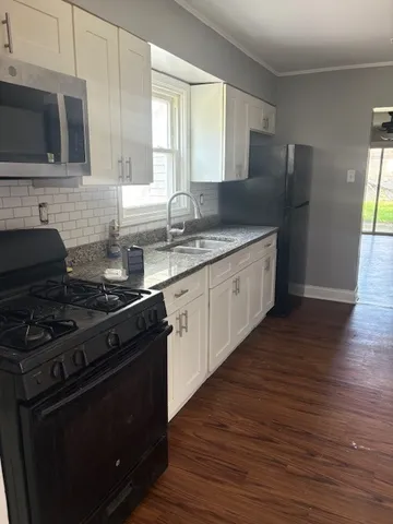 a kitchen with stainless steel appliances granite countertop a stove a sink and a microwave