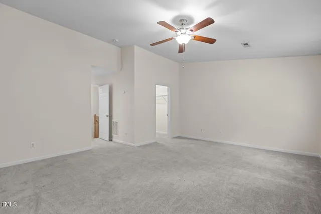 an empty room with chandelier fan