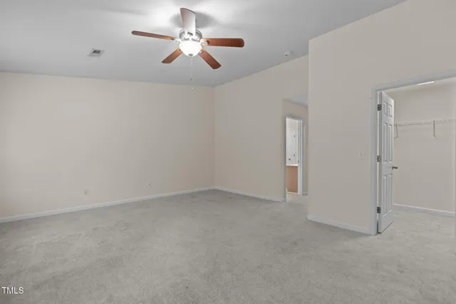 an empty room with chandelier fan