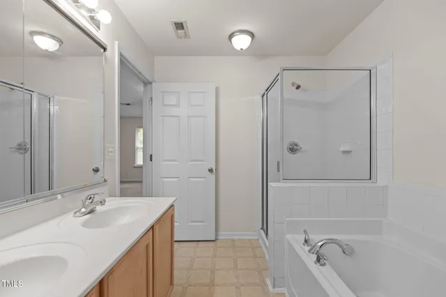 a bathroom with a tub sink shower and mirror
