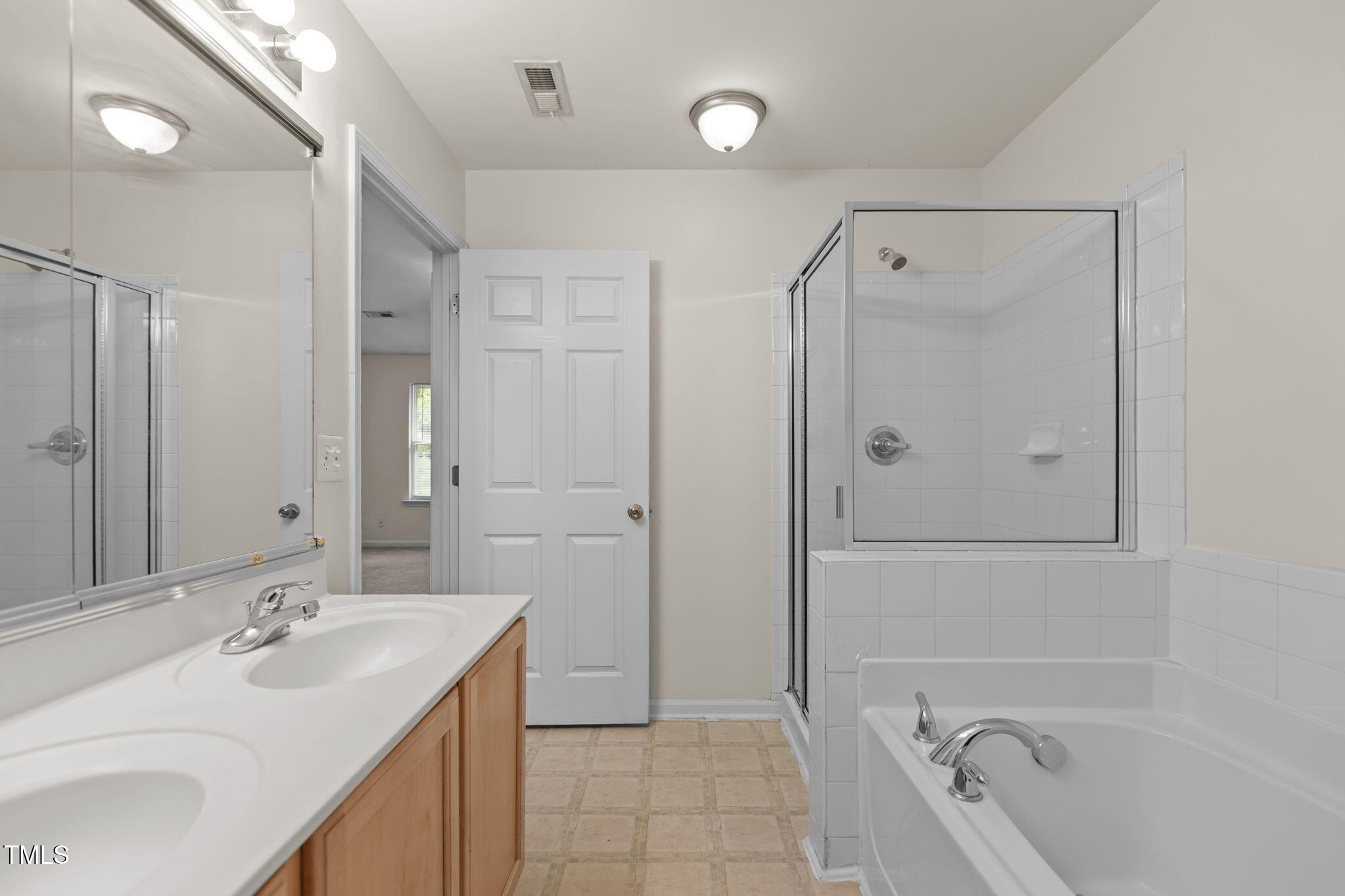 11720 Mezzanine Drive, Unit 103 Raleigh, NC 27614 - Photo 14 of 18 a bathroom with a tub sink shower and mirror