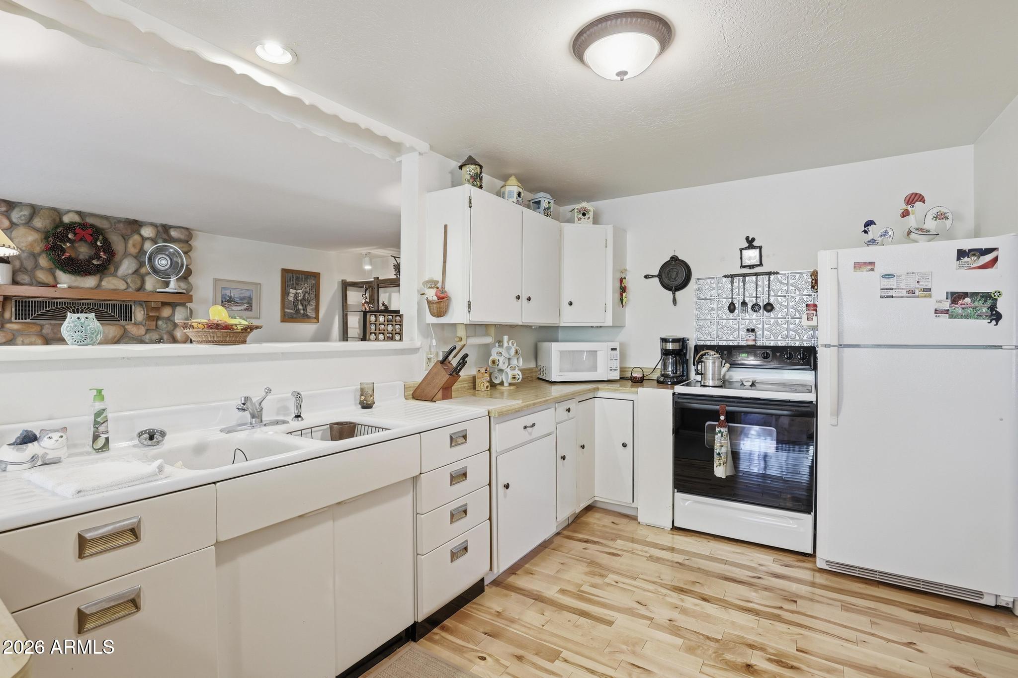 250 East Saddle Mountain Road Payson, AZ 85541 - Photo 11 of 32 a kitchen with granite countertop white cabinets and white appliances
