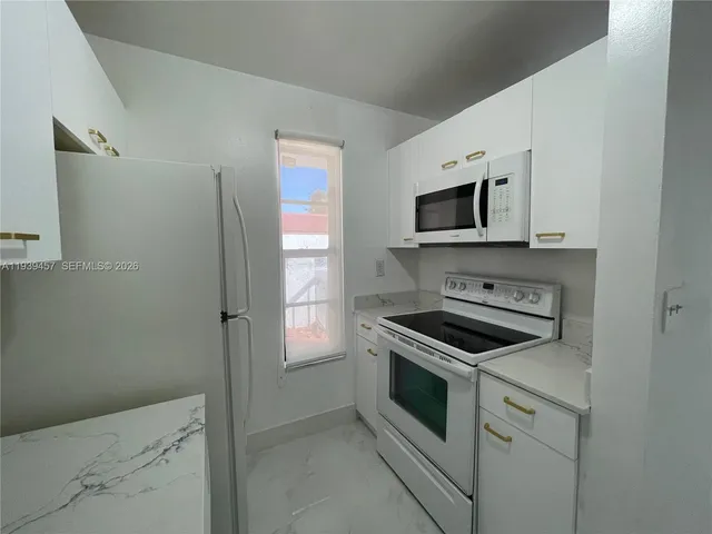 a kitchen with stainless steel appliances white cabinets and stove