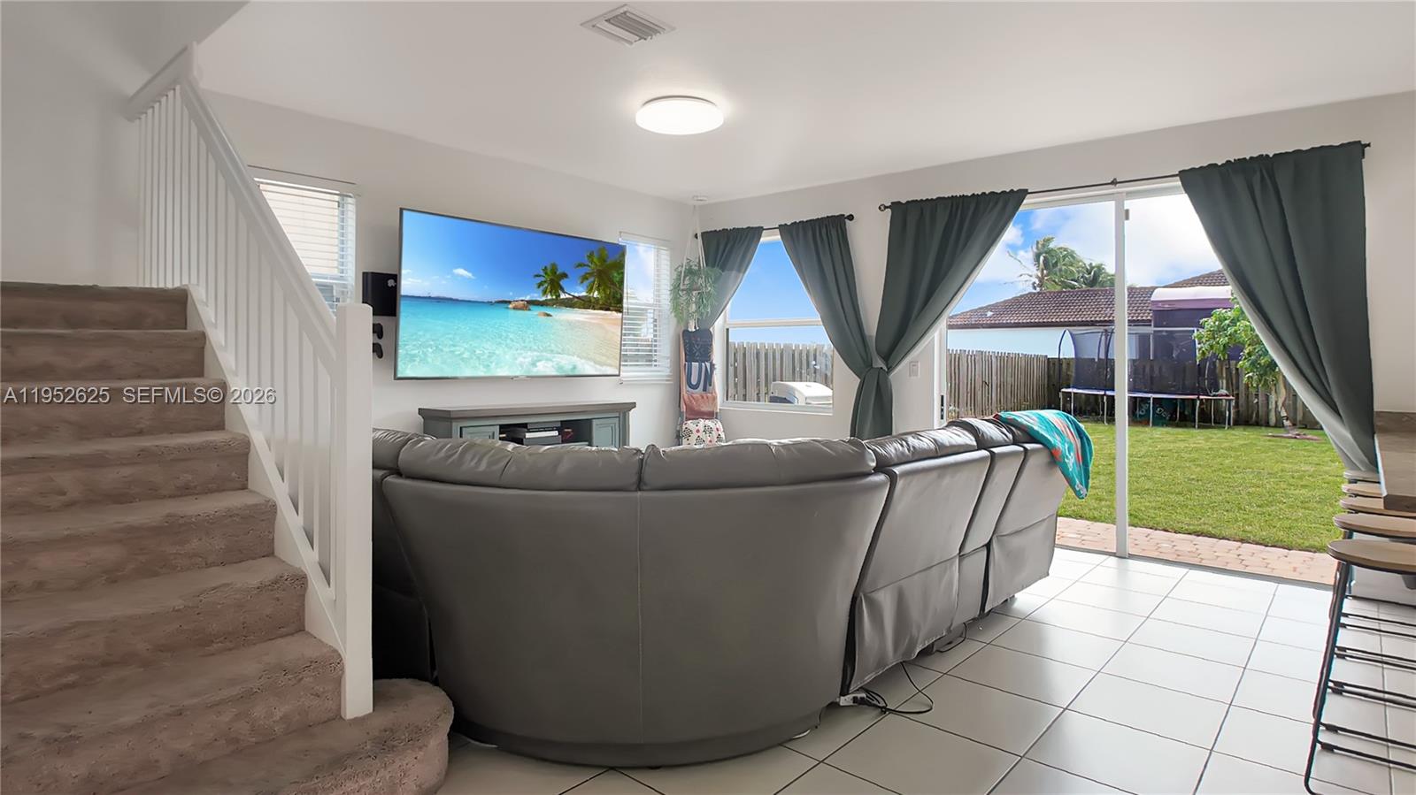 13160 Southwest 280th Street Homestead, FL 33033 - Photo 10 of 44 a living room with a couch and a floor to ceiling window
