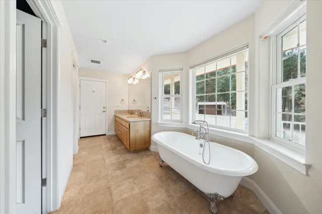 an empty room with wooden floor chandelier fan and windows