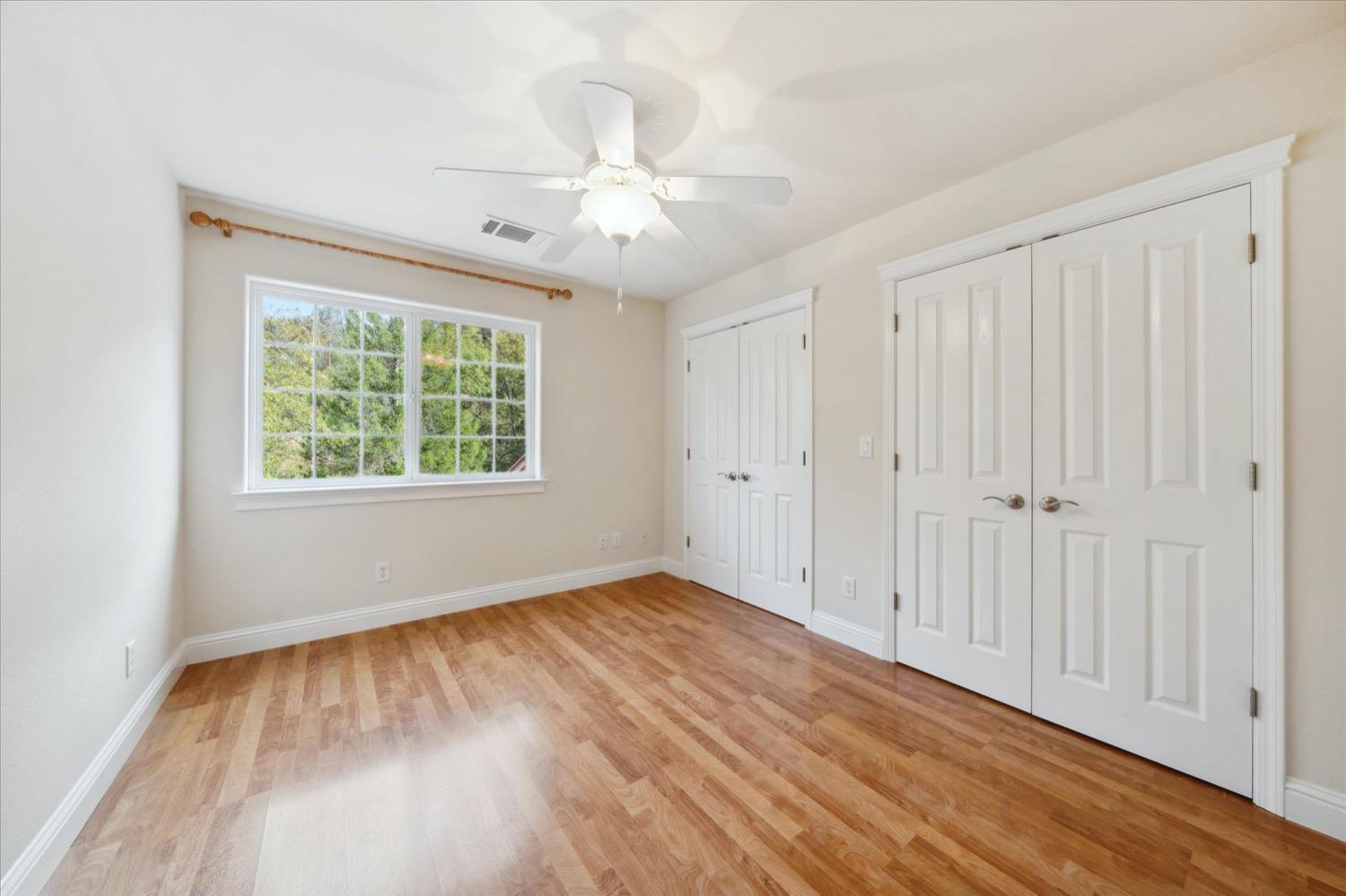 2995 Goose Ranch Road Lewiston, CA 96052 - Photo 26 of 87 an empty room with wooden floor chandelier fan and windows