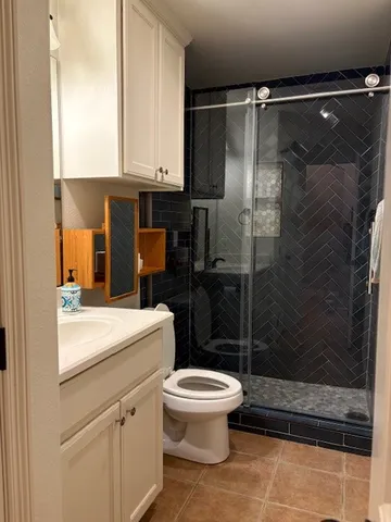 a bathroom with a shower a toilet and a sink