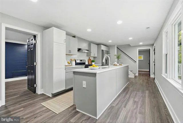 a kitchen with cabinets and wooden floor