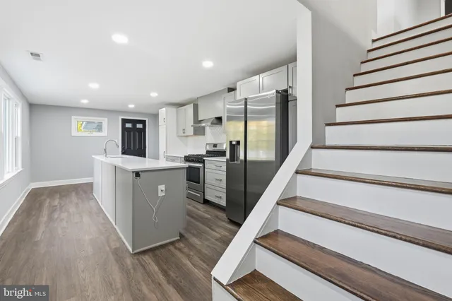 a kitchen with cabinets and wooden floors