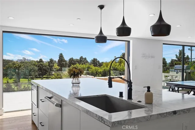 a kitchen with a sink a counter top space and a wooden floor