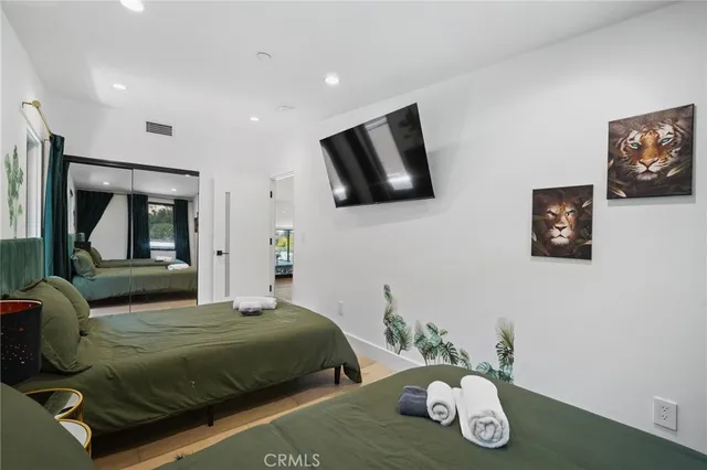 a bedroom with a bed and large flat screen tv