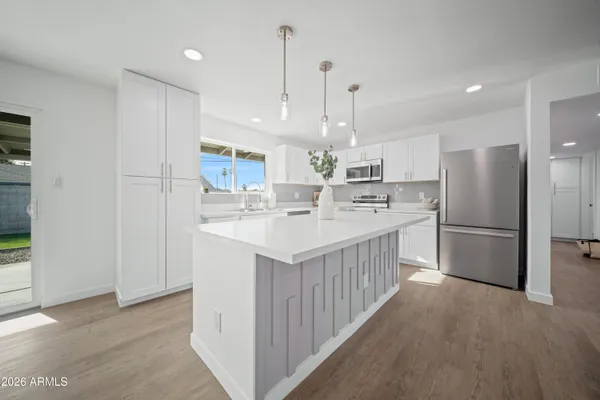 a kitchen with a refrigerator sink and cabinets