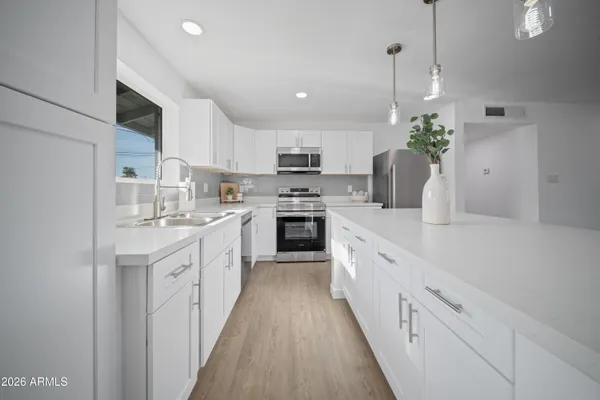 a kitchen with stainless steel appliances granite countertop a sink and a stove top oven
