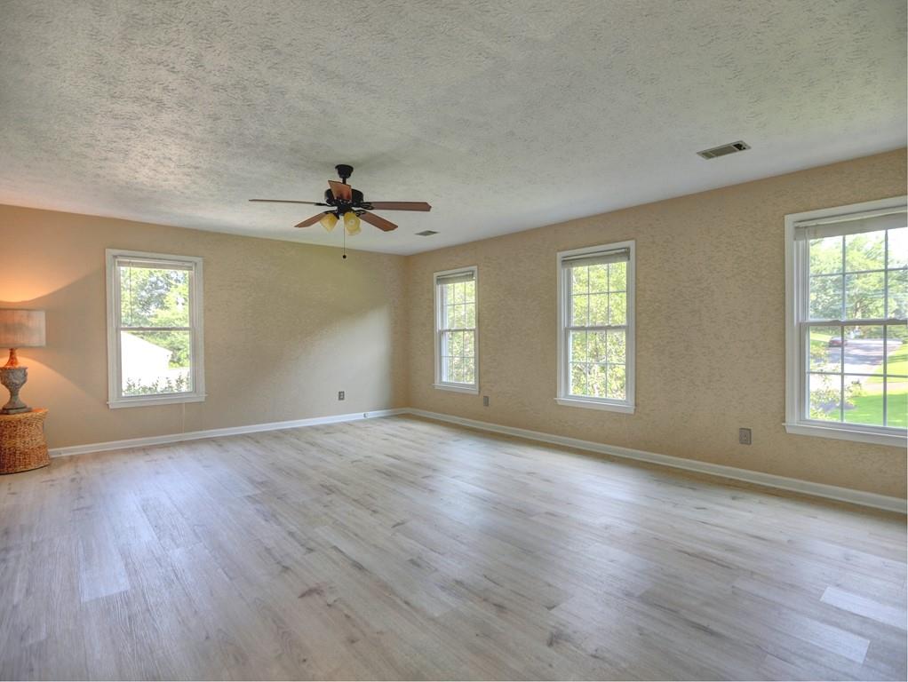 4512 Woodlawn Lake Drive Marietta, GA 30068 - Photo 28 of 55 an empty room with wooden floor chandelier and windows