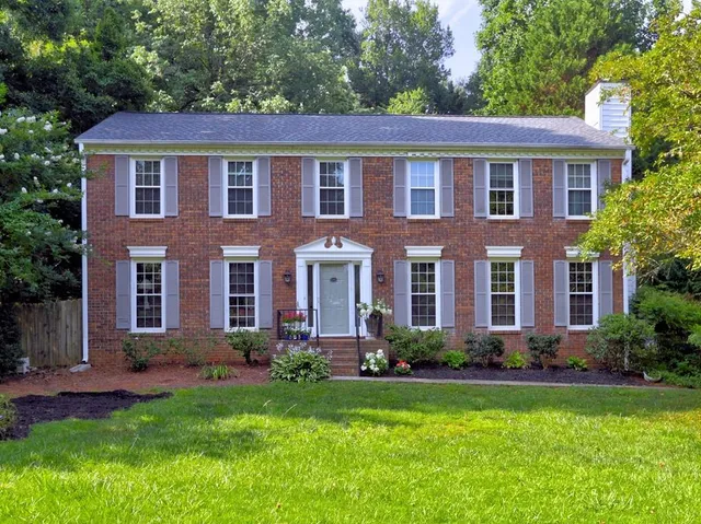 a front view of a house with a yard and trees