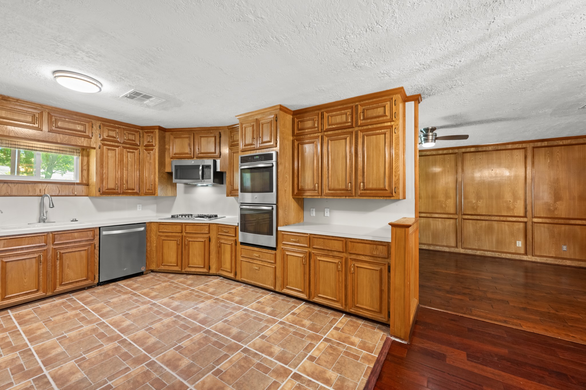 616 Cannan Drive Angleton, TX 77515 - Photo 11 of 49 Warm wood cabinetry, extensive counter space, and built-in stainless steel appliances make this kitchen both stylish and highly functional. The open layout connects seamlessly to the adjacent dining area, creating an ideal space for meal preparation, entertaining, and everyday living.