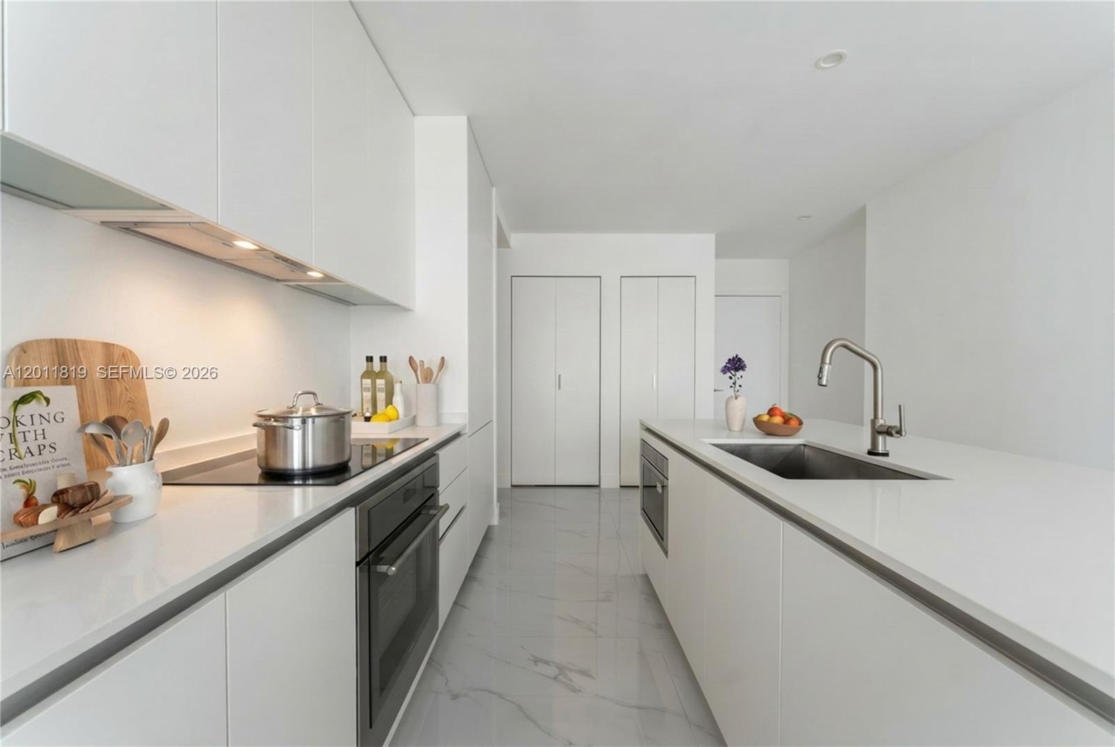 700 Northeast 24th Street, Unit 2504 Miami, FL 33137 - Photo 10 of 52 Modern chef’s kitchen equipped with custom Italian cabinetry, premium Miele appliances, integrated stone countertops, and a waterfall island perfect for entertaining. Image i virtually staged.