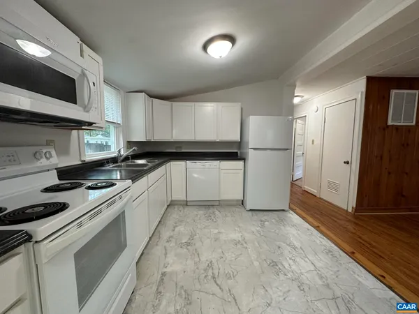 a kitchen with a refrigerator sink and cabinets