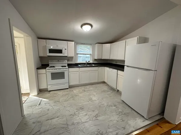 a kitchen with granite countertop a refrigerator stove a sink dishwasher and microwave