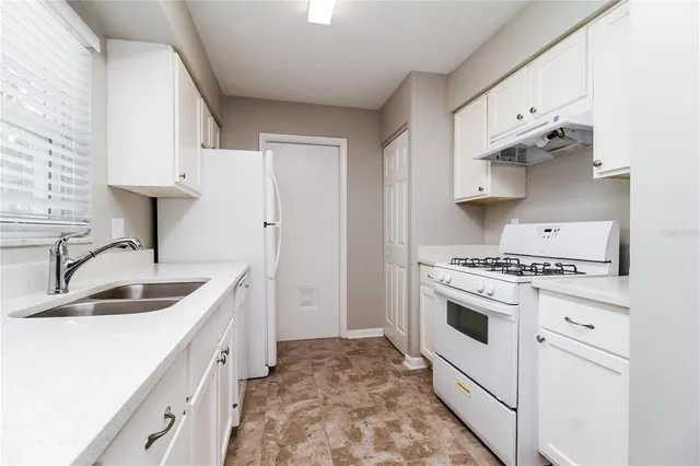 a kitchen with stainless steel appliances granite countertop a sink and a stove