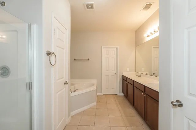 a bathroom with a tub sink shower and mirror