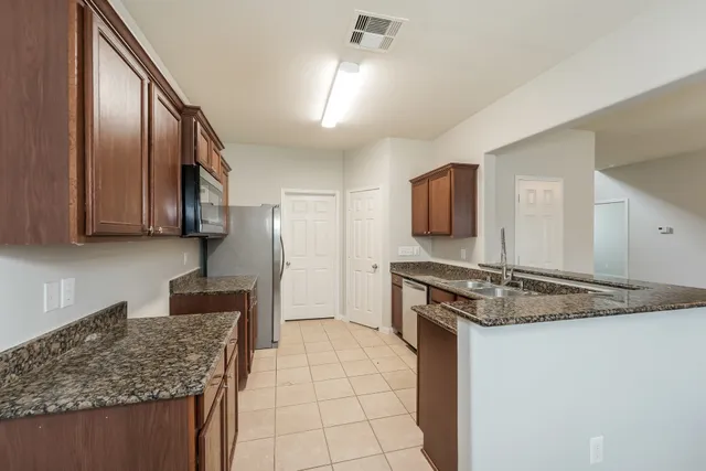 a kitchen with stainless steel appliances granite countertop a sink stove and refrigerator
