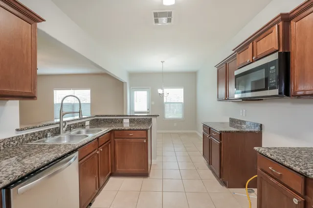 a kitchen with stainless steel appliances granite countertop a sink stove and microwave