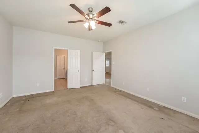 an empty room with closet and fan