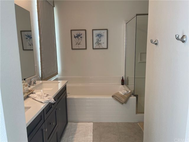 a bathroom with a granite countertop bathtub sink and mirror
